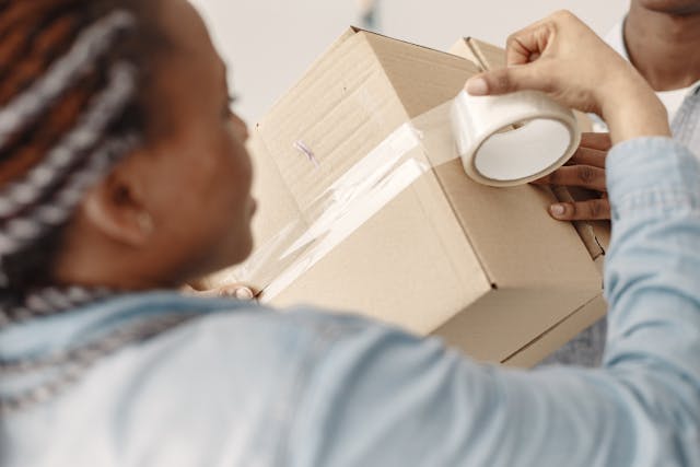 person taping moving boxes